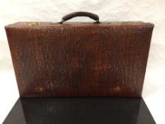 A mid twentieth century crocodile effect leather suitcase, with canvas lined interior, with key,