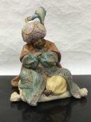 A Lladro bisque figure of a seated Persian gentleman, height 31cm.