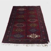 A wool Eastern carpet on red ground of geometric design, 77 cm x 122 cm.