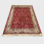 A silk finished Persian carpet on red ground, 155 cm x 227 cm.