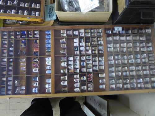 Printer's type tray containing a large quantity of assorted thimbles including examples in china