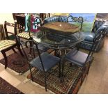 A glass topped dining table and four chairs