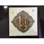 A framed piece of antique fabric bearing initials