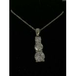 A graduated three stone diamond pendant set in platinum, suspended upon an 18ct white gold chain.