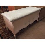 A white blanket box with upholstered stop