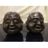 A pair of Chinese buddha heads with character marks to base