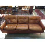 A late 20th century three seater button leather settee in tan covering