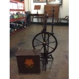 An antique spinning wheel and small painted wall cabinet