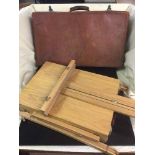 A vintage leather luggage case and a folding storage artist's easel