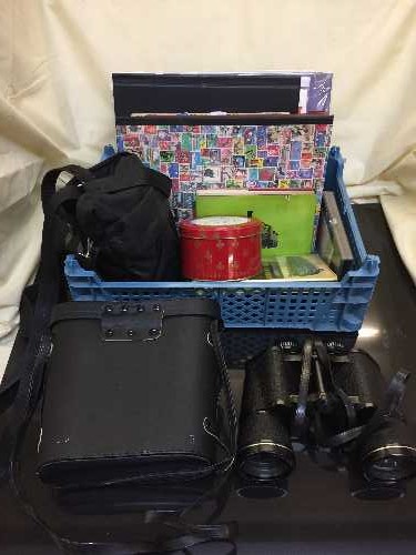 A basket of cased Conquest binoculars, camera in bag,