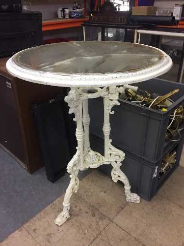 A circular cast iron glass top patio table