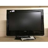 A Grundig 26 inch LCD TV with remote and instructions