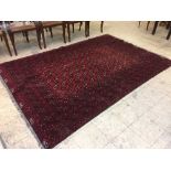 A fringed wool Persian rug on red ground