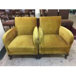 A pair of early 20th century armchairs upholstered in gold fabric