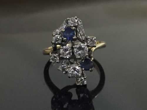 A sapphire and diamond cluster ring, the stones in raised claw settings,