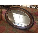 An oval Edwardian oak framed mirror