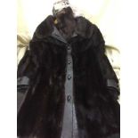 A lady's fur coat with leather trim and a fur stole