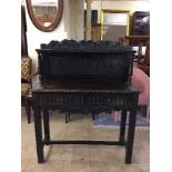 A heavily carved oak early 20th century side table fitted two drawers