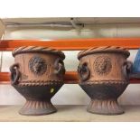 A pair of terracotta lion mask planters