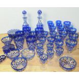 Suite of Bohemian blue flashed glassware with circular facet cut decoration,