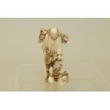 Small Japanese Meiji period carved ivory okimono of a man carrying a bundle of sticks, unsigned,