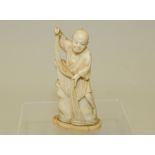 Japanese Meiji period carved marine ivory figure of a fisherman bringing in his net, unsigned,