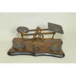 Set of Victorian postal scales with shaped mahogany base & six brass weights,