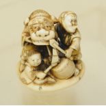 Japanese Meiji period carved ivory netsuke of three children, one in a dragon costume, one wearing a