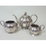 Chinese silver three piece tea set of hammered globular melon form with bamboo handles,