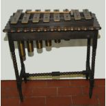 Late 19th/early 20th century xylophone with eight brass bars on oak stand, 27" wide.