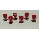 Set of six ruby glass liqueur or shot glasses, the rounded bowls on knopped stem & circular foot,