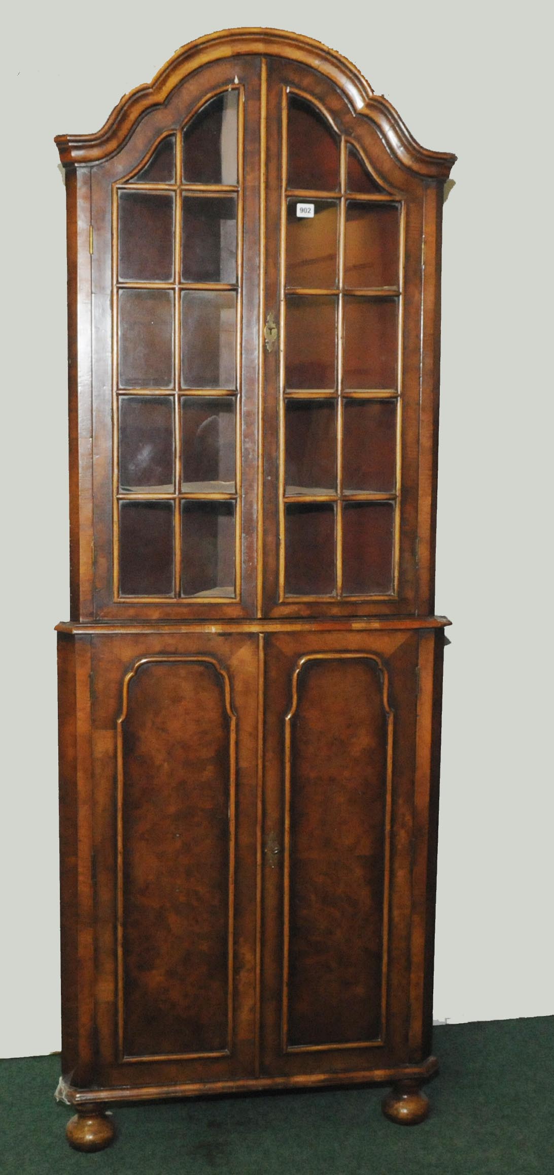 Late 19th century walnut standing corner cabinet with scrolling domed pediment above pair of multi