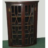 19th century mahogany bow front hanging corner cabinet with moulded pediment above glazed astragal