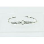 Edwardian expanding bracelet of delicate openwork form with a pearl & diamonds, in platinum.