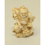 Japanese Meiji period carved ivory netsuke of a deity quelling a demon, unsigned, 2" high.