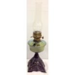 A wrought iron and glass oil lamp with chimney 58cm