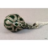 A silver Faberge style egg pendant on silver chain