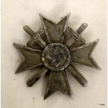 A Nazi War Merit Cross with Swords badge. Missing its pin to the reverse