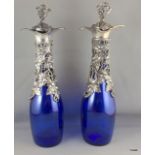 A pair of silver plated Bristol Blue grape and vine decoration decanters