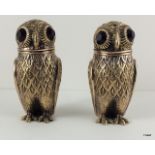 A pair of Continental silver owl condiments with glass eyes