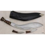 A Kukri in its leather bound wooden scabbard complete with both sharpening knives