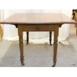 A double drop-leaf Pembroke table with turned legs on castors 74 x 108 x 100cm