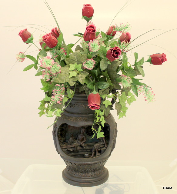 A large indoor electric water feature in the style of a Grecian urn with floral arrangement