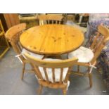 A pine round table and 4 matching chairs