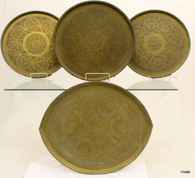 4 Eastern brass trays with engraved decoration, some Islamic script, largest 51cm in diameter