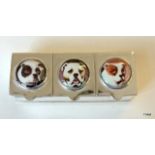 A three section silver pill box with dog enamel images to the lids