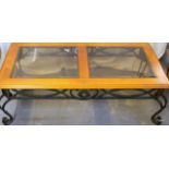 An iron framed glass and wood topped coffee table 42 x 121 x 63
