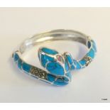 A silver and turquoise snake bangle