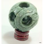 A Chinese jade carved concentric puzzle ball on stand