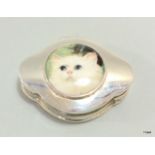 A silver pill box with cat motif to the lid